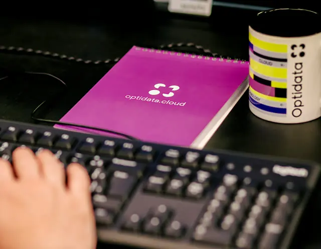 Optidata Cloud notebook and mug on a desk